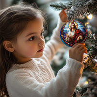 Small Jesus ornament with stained-glass portrait hanging from a Christmas tree