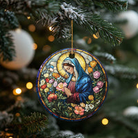Circular Christian Christmas ornament showing Mary in blue robe with a floral garden, gold hanging loop