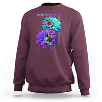 Maroon crewneck sweatshirt with turquoise and purple flower graphic and 'choose to keep going' text