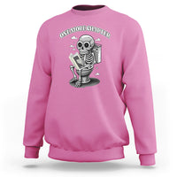 Pink sweatshirt with skeleton holding a book graphic on the chest.