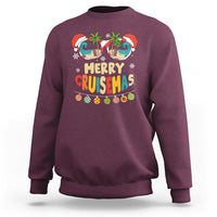 Maroon crewneck sweatshirt with “Merry Cruisemas” palm tree sunglasses graphic