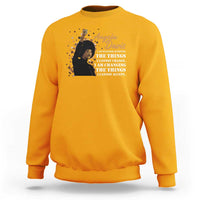 Gold crewneck sweatshirt with Angela Davis graphic and activist quote print on chest