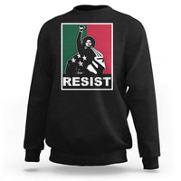 Black crewneck sweatshirt with “RESIST” graphic and raised-fist activist artwork.