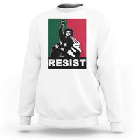 White crewneck sweatshirt with “RESIST” graphic and raised-fist activist artwork.