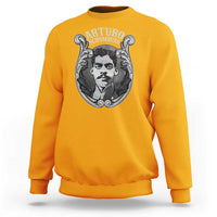 Gold crewneck sweatshirt with large Arturo Schomburg portrait graphic on chest