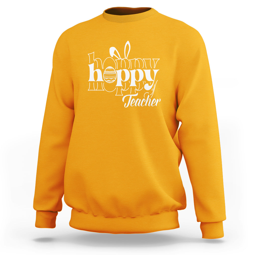 Gold crewneck sweatshirt with white “Happy Hoppy Teacher” bunny and egg graphic