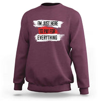 Maroon sweatshirt with front text graphic: “I’m just here to pay for everything”