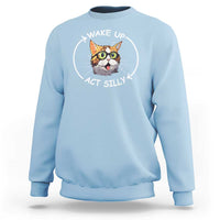 Light blue crewneck sweatshirt with cat meme graphic reading “WAKE UP ACT SILLY”.