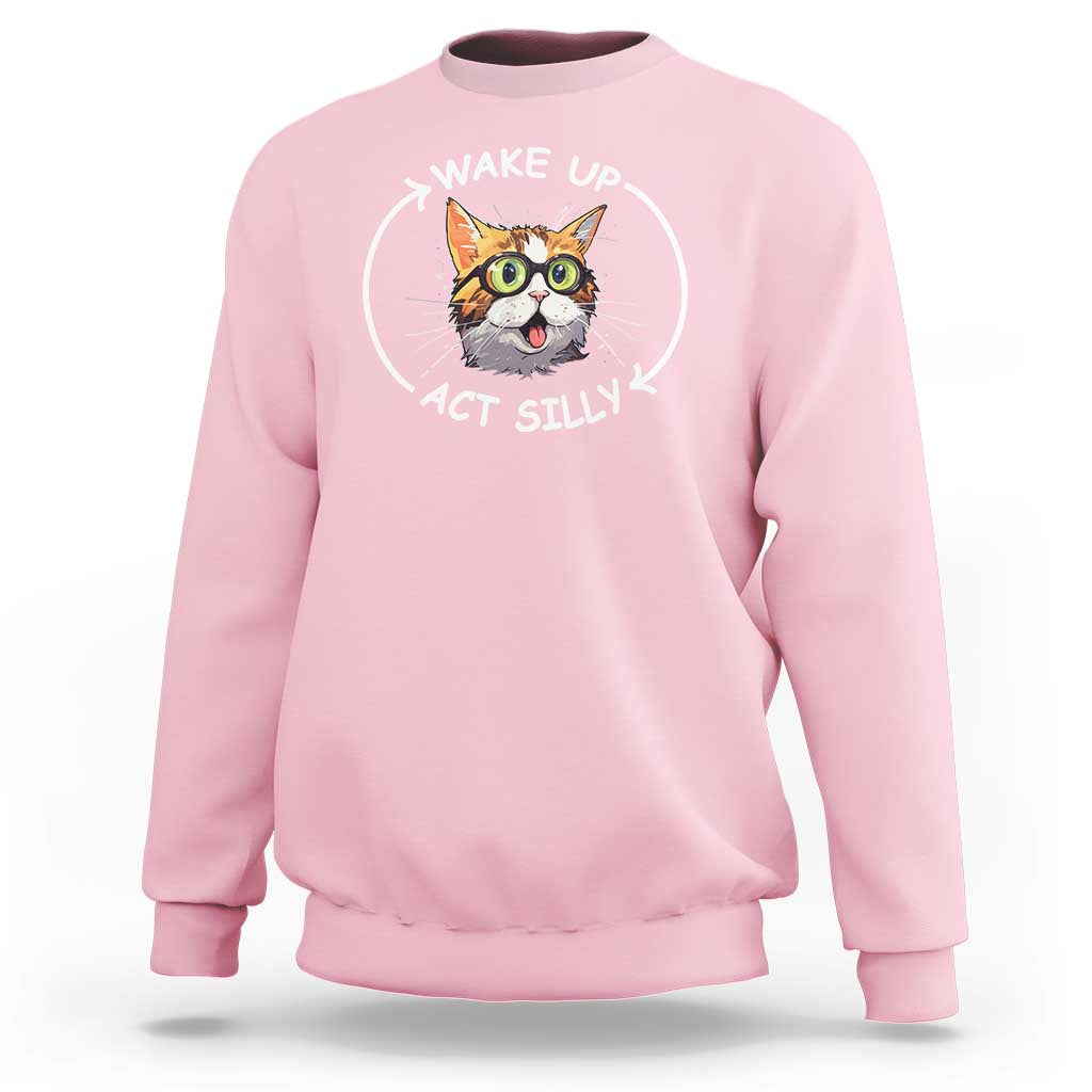 Light pink crewneck sweatshirt with cat meme graphic reading “WAKE UP ACT SILLY”.