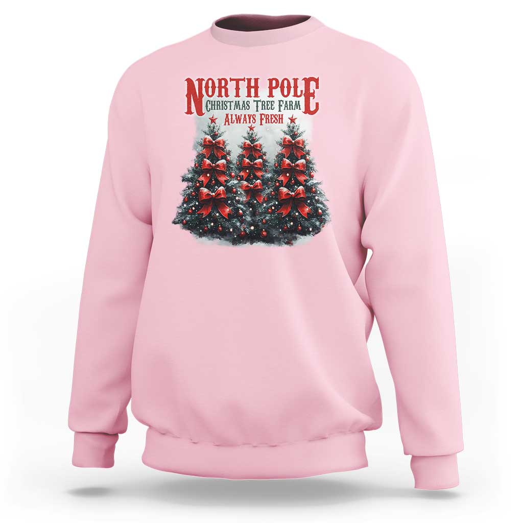 Light pink Christmas sweatshirt with North Pole tree graphic and red text