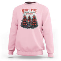 Light pink Christmas sweatshirt with North Pole tree graphic and red text
