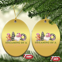 Pair of gold oval ornaments with pink holiday character graphic, each hanging from a gold cord