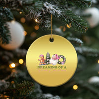 Gold circle Christmas ornament hanging from a gold cord, with pink holiday character graphic