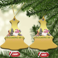 Pair of gold Christmas bell ornaments on tree, showing pink holiday character graphic