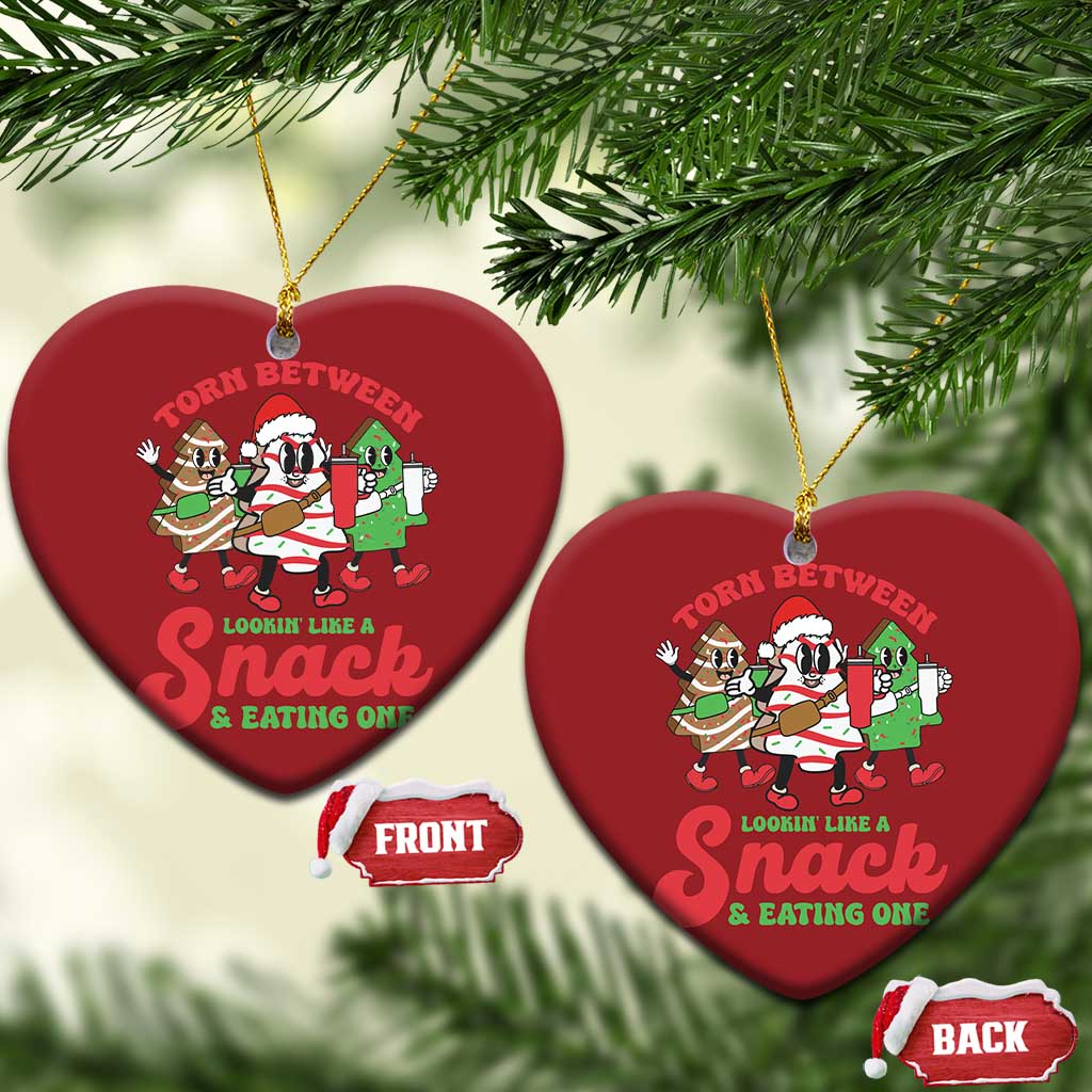 Two red heart-shaped Christmas ornaments with cartoon “Torn Between” snack design and gold loops