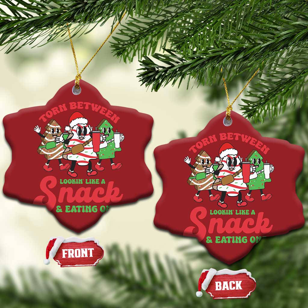 Two red heart-shaped Christmas ornaments with cartoon “Torn Between” snack design and gold loops
