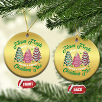 Two gold round Christmas ornaments with cake tree graphics and gold hanging loops
