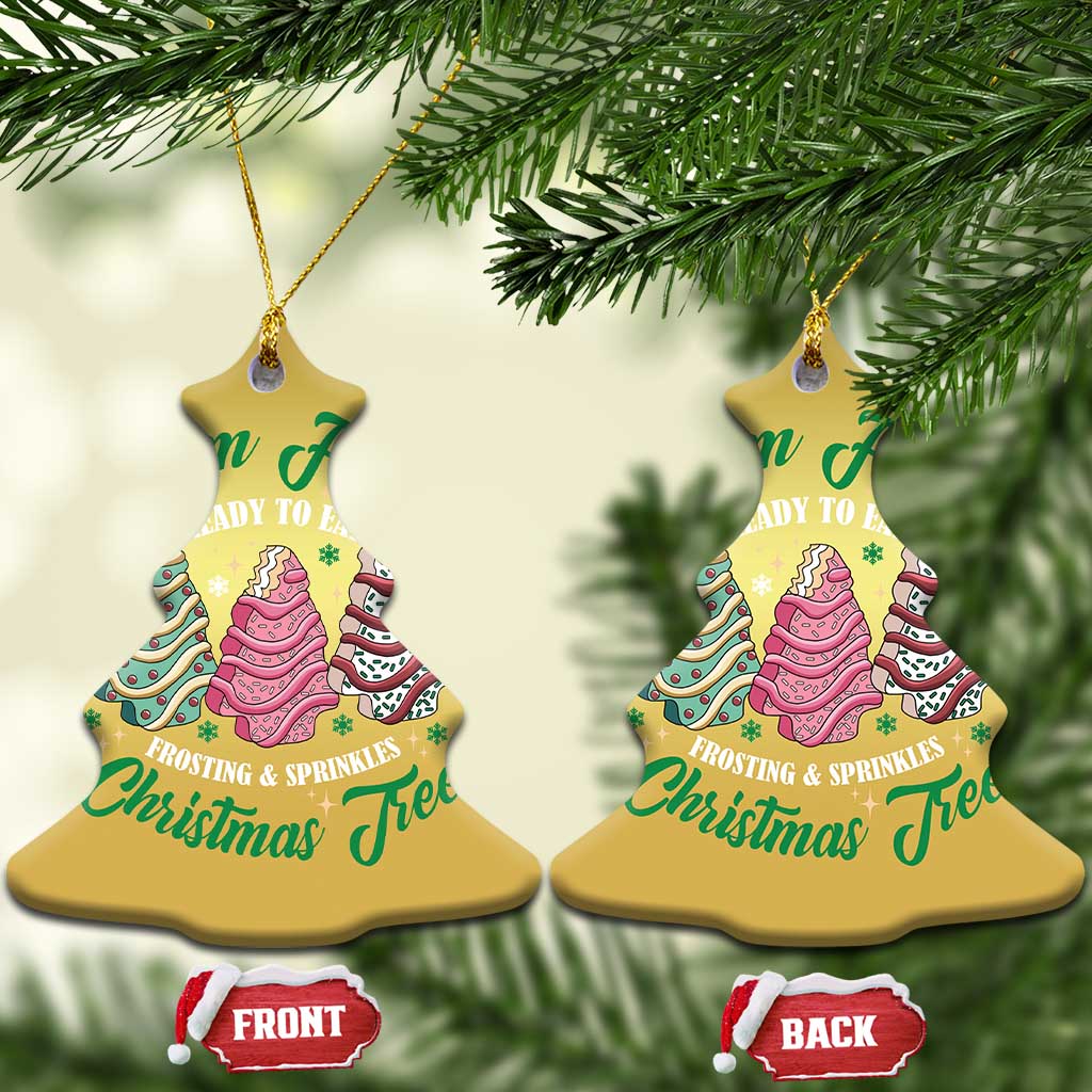 Two gold bell-shaped Christmas ornaments with cake tree graphics and front/back tags