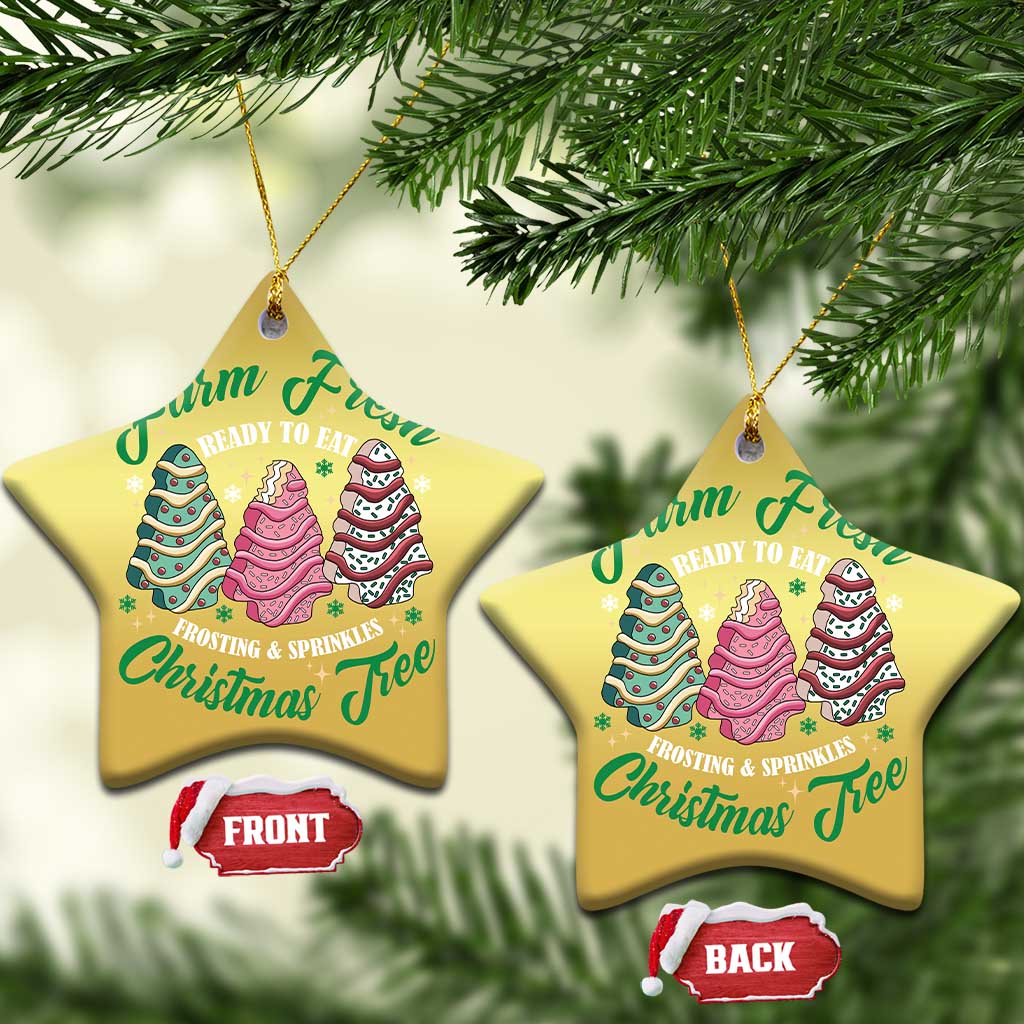 Two gold star-shaped Christmas ornaments with cake tree graphics and gold hanging loops