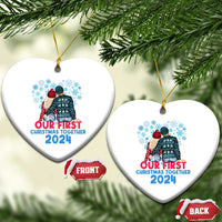 Two white heart-shaped Christmas ornaments with couple graphic and “Our First Christmas Together 2024”