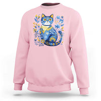 Light pink sweatshirt with blue floral cat graphic on the chest