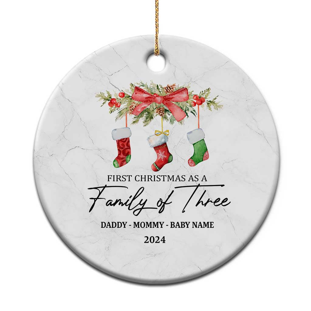 White round Christmas ornament with red bow, stockings, and Family of Three 2024 text