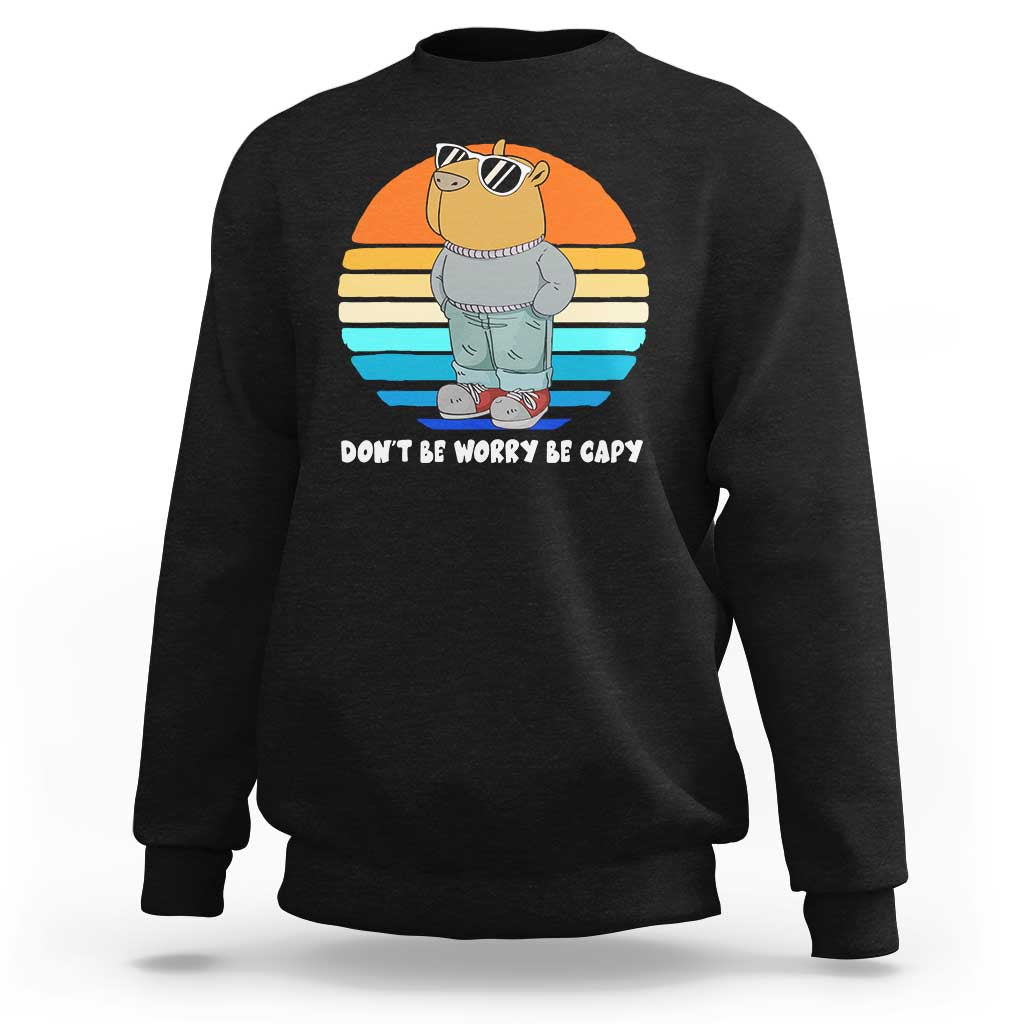 Black crewneck sweatshirt with capybara graphic and “DON’T BE WORRY BE CAPY” text