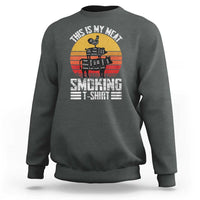 Dark heather gray crewneck sweatshirt with BBQ smoker graphic and “Smoking” text on front