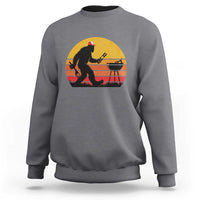 Gray crewneck sweatshirt with Bigfoot grilling graphic on the chest