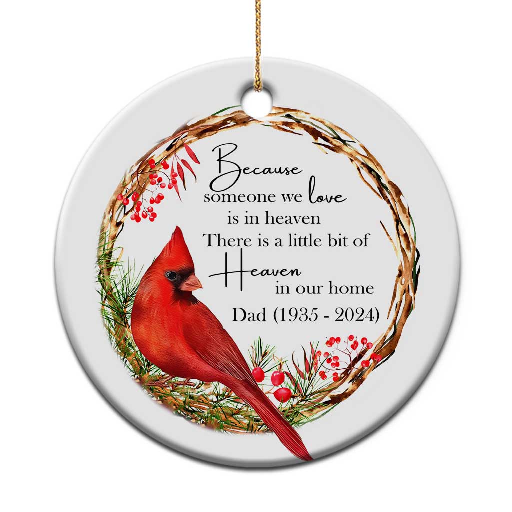 White round memorial ornament with red cardinal, berries, and engraved condolence text; gold loop