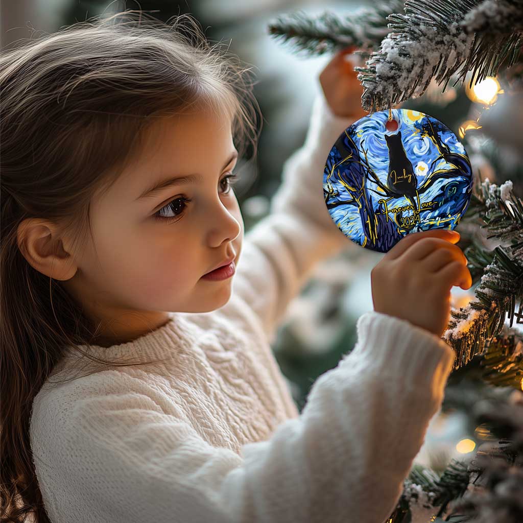 Child holding a personalized cat memorial round Christmas ornament in blue with black cat