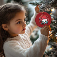 Red round Christmas ornament with Santa portrait design, hanging from a gold cord