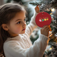 Red round pickleball Christmas ornament held by a child near a decorated tree, gold loop