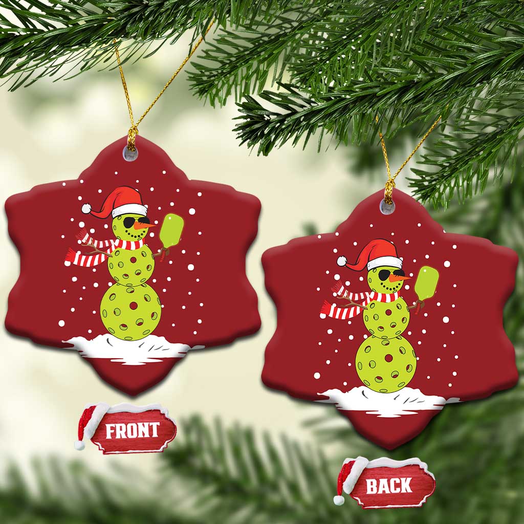 Two red star-shaped ornaments with cartoon snowman holding a paddle, gold hooks, front/back tags