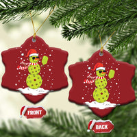 Two red star-shaped ornaments with cartoon snowman holding a paddle, gold hooks, front/back tags
