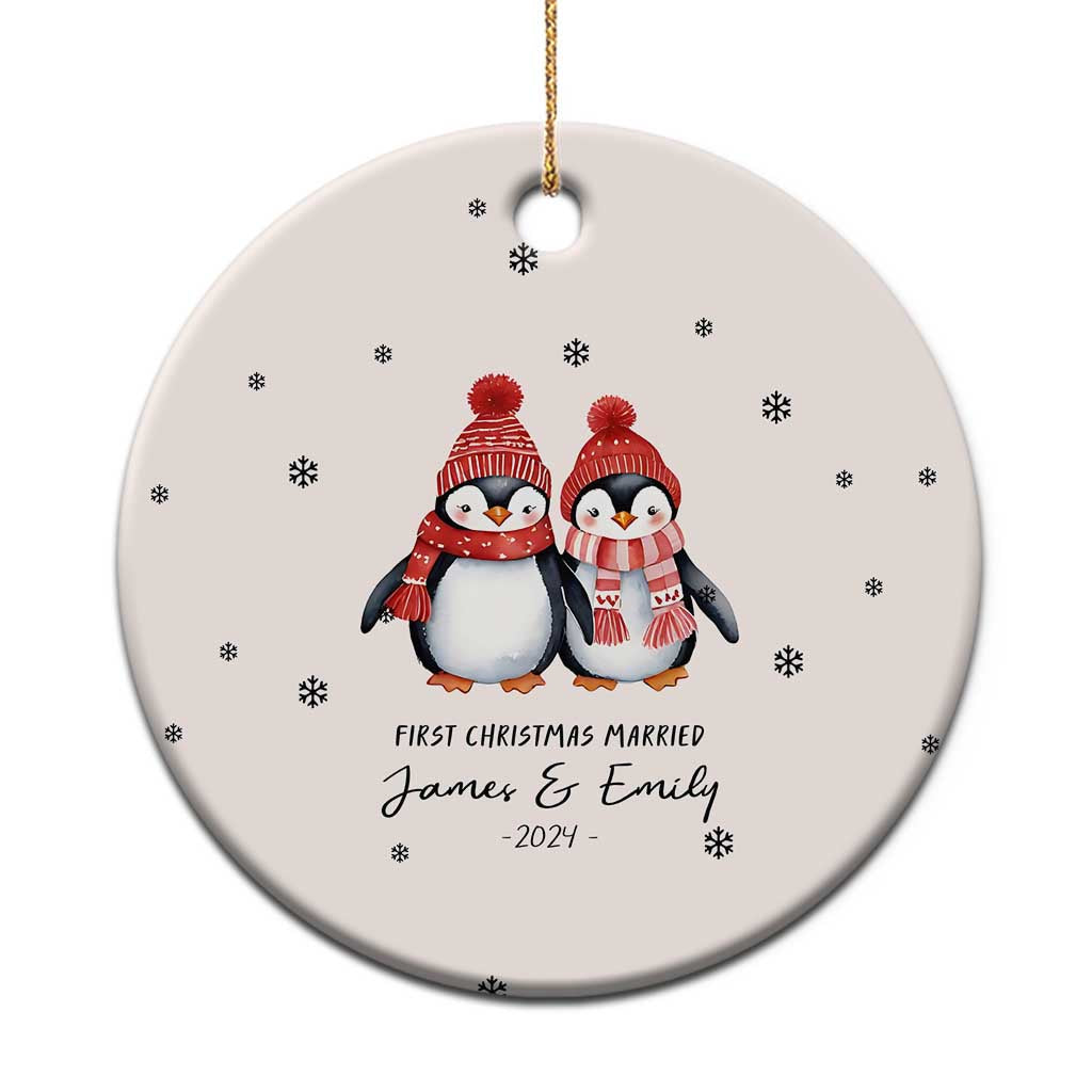 Cream round Christmas ornament with two penguins, snowflakes, and “First Christmas Married” name.