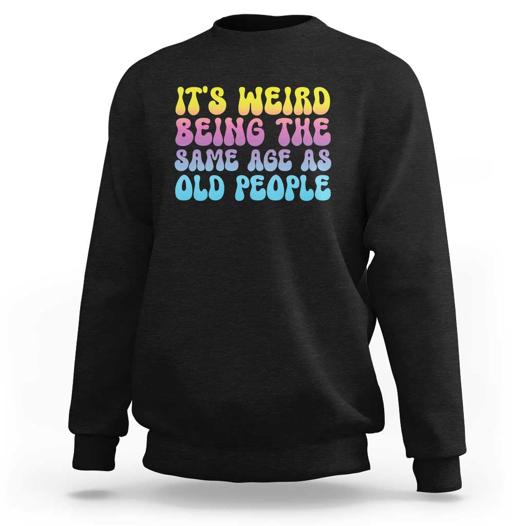 Black crewneck sweatshirt with multicolor 'It's weird' and 'old people' text graphic