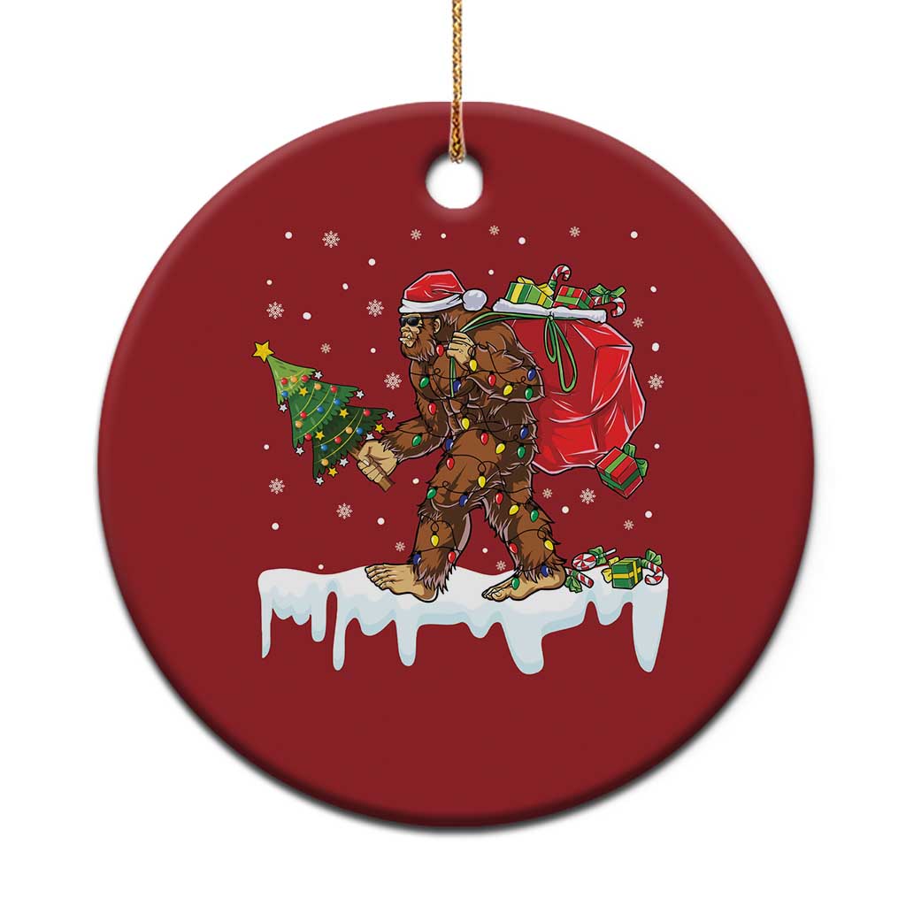 Red round Christmas tree ornament with Bigfoot holding a gift box design