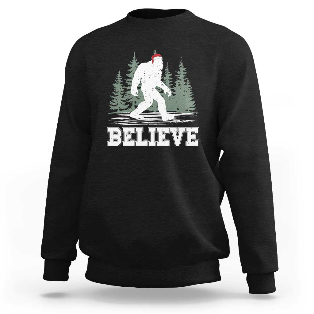 Black Bigfoot Christmas sweatshirt with 'BELIEVE' graphic and Santa hat