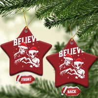 Two red star-shaped ornaments with “BELIEVE” and alien and Bigfoot graphics