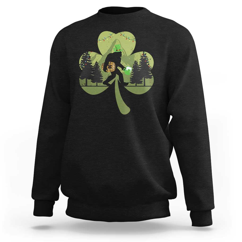 Black sweatshirt with Bigfoot graphic holding a green shamrock and clover leaves