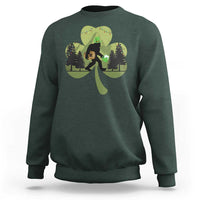 Dark forest green sweatshirt with Bigfoot graphic holding a green shamrock and clover leaves