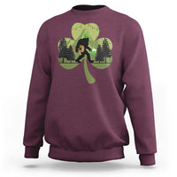 Maroon sweatshirt with Bigfoot graphic holding a green shamrock and clover leaves