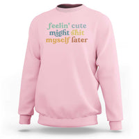 Light pink sweatshirt with front graphic text in green and orange