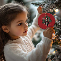 Red round motorcycle Santa Christmas ornament held by a child near a tree
