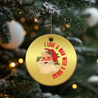 Gold round Santa Christmas ornament hanging on a tree branch with red love message