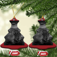 Two red teardrop Christmas ornaments with capybara selfie and UFOs, gold loops on top.