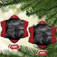 Two red shirt-shaped Christmas ornaments with capybara selfie and UFOs, gold hanging loops.