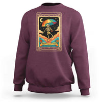 Maroon crewneck sweatshirt with front graphic of rainbow umbrella skeleton and stars