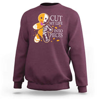 Maroon crewneck sweatshirt with skull and guitars graphic and “CUT MY LIFE INTO PIECES” text.